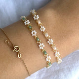 Delicate elegant beaded bracelet in pastel colours with small golden details and white daisy flowers
