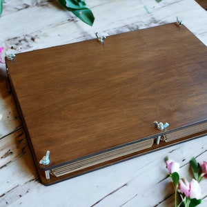 Wooden flower press with hinged lid and two metal clasps for pressing plants