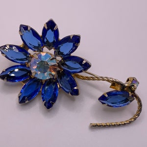 Blue rhinestone flower brooch with gold-tone pin, stem and leaf