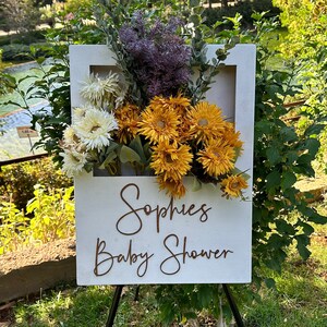 Wooden baby shower flower box with mixed blooms and cursive 'Sophie’s Baby Shower' sign