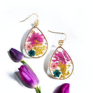 Teardrop resin earrings with pressed pink and purple flowers, blue accents, gold hooks