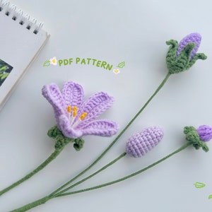Purple crochet flower bouquet with three blossoms and green stems, handmade