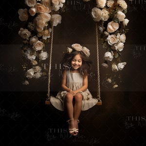 Flower swing backdrop: child sitting on rope swing with pale rose floral arch