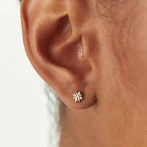 14k gold floral diamond stud earrings with tiny flower design on ear