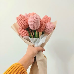 Pink crochet tulip bouquet with green stems, wrapped in kraft paper.
