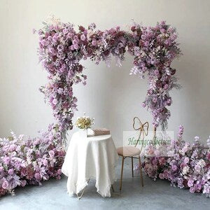Lilac artificial flower arch garland with dense purple blooms forming a wedding backdrop