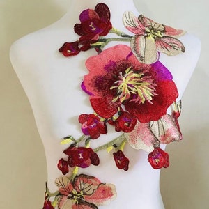 Embroidered flower applique set with red, pink and green stitched details on fabric base