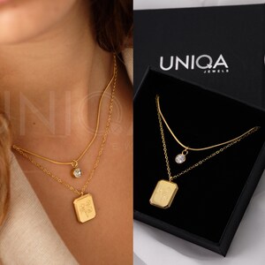 Gold-tone square pendant necklace with small birth-flower charm on chain