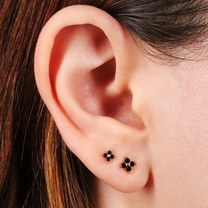 Four-leaf clover black stone stud earrings on ear, small sterling silver posts