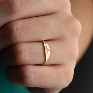 Gold dainty engraved flower stacking ring on finger