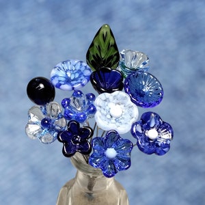 Handmade glass flower bouquet with blue and dark blue blossoms and one green leaf