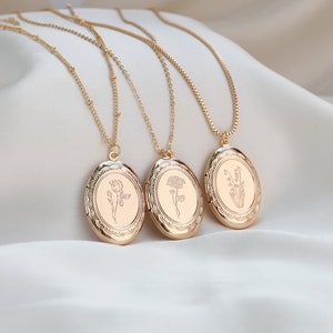 Gold-tone oval locket necklaces with engraved front and small birth-flower motif