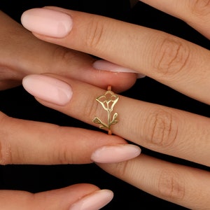 Gold-tone flower ring with small leaf accents