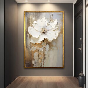 Framed canvas wall art with large white abstract flower and textured gold-toned accents