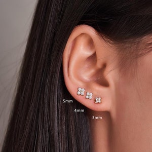 Sterling silver flower CZ stud earrings with tiny sparkling stones, small round studs.