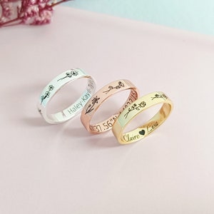 Three personalized birth flower rings in silver, rose gold, and gold with engraved names
