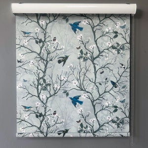 Blue branch and bird roller shade with floral pattern on light fabric