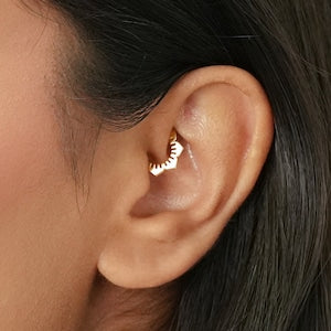 Gold daith clicker cartilage hoop earring with small flower-like charm