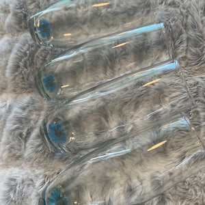 Glass champagne flutes with encapsulated dried royal blue flowers, set of three