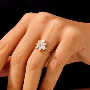Gold flower engagement ring with a clustered round-stone center