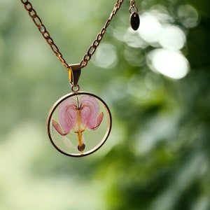 Gold necklace with circular bleeding heart flower pendant and link chain