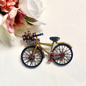 Multicolour crystal bicycle brooch pin with blue wheel detailing and silver-tone frame