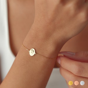 Sterling silver birth-flower bracelet with a small round charm on a thin chain