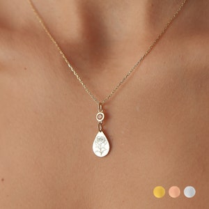 Small silver birth flower charm pendant on a delicate chain