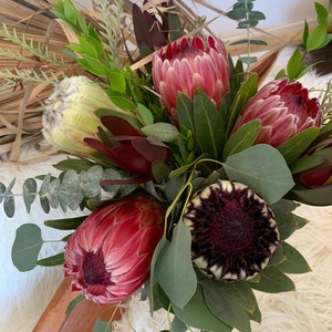 Protea flower bouquet with pink proteas, cream blooms, and green eucalyptus leaves