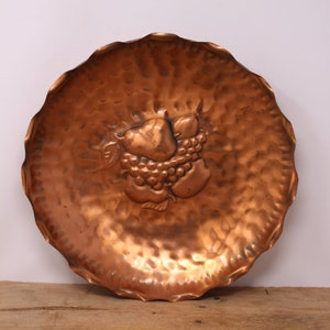 Copper fruit-embossed wall bowl with hammered texture and fluted edge