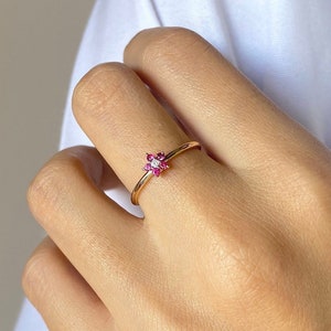 14k gold flower cluster ring with small pink gemstone center, slim band