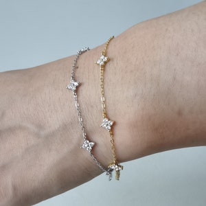 Dainty flower charm bracelet stack, silver and gold with small diamond-like blossoms