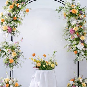 Artificial flower swag arch with greenery, white and yellow blooms for wedding backdrop