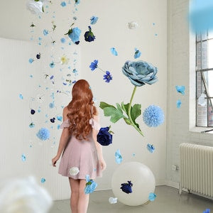 Blue hanging flower garland with layered blooms and butterfly decorations on wall