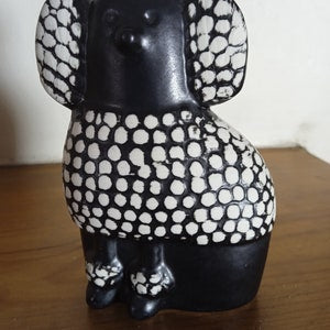 Glazed ceramic poodle figurine, black with white dot pattern on ears and body.