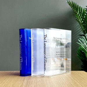 Personalizable acrylic book vase, clear front with blue book spines and printed text.