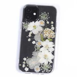 Pressed flower phone case with white daisies in a clear transparent frame