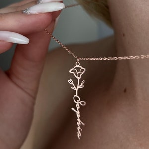 Dainty gold-tone birth flower name necklace with small floral pendant and cursive charm