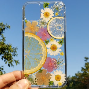 Transparent phone case with pressed daisies and a dried citrus slice, hand-finished