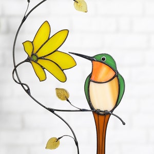 Stained glass hummingbird suncatcher with yellow butterfly, hanging on metal vine