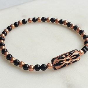 Onyx bead bracelet with rose-gold copper clasp and engraved floral charm