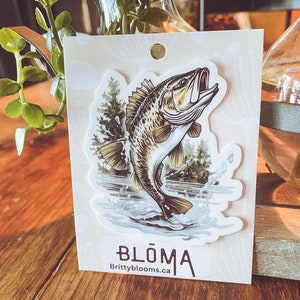 Fish vinyl sticker on backing card, showing a leaping bass with trees and water scene.