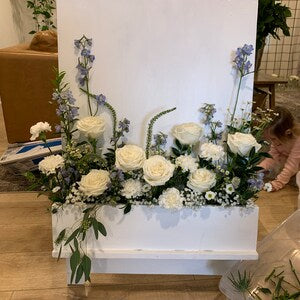 Floral flower box arrangement with white blooms and green foliage