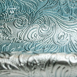Embossed flower-pattern lambskin material, light blue metallic swirl detail