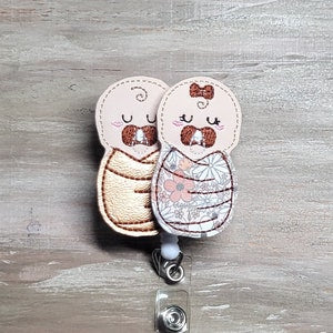Baby swaddle fabric charms with smiling faces and pacifier clip hardware