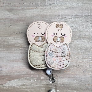 Beige baby fabric clip with heart appliques and floral print, smiling faces