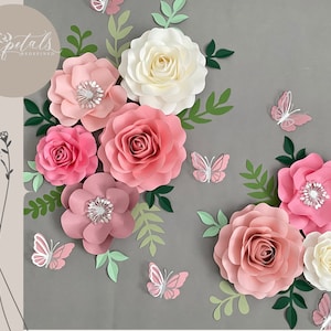 Pink and white paper flower wall decor with butterflies and layered rosettes
