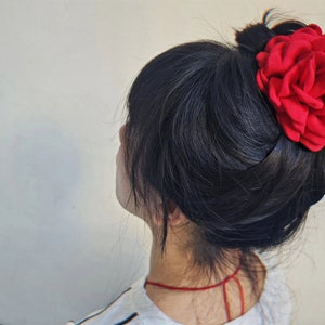 Red fabric flower hair claw clip on dark hair
