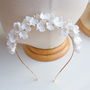 White floral bridal headband with clustered 3D flower accents on thin metal band