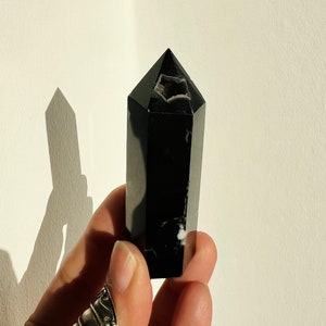 Black flower agate crystal obelisk with faceted pointed top